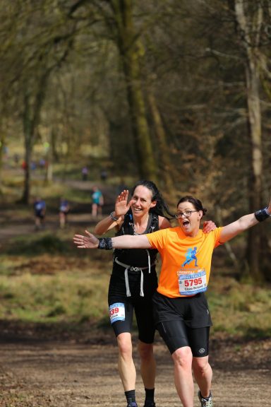 two happy women running in a marathon